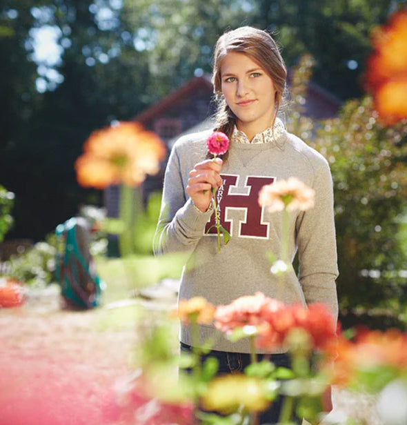 A girl Holding a Flower with harvard sweatshirt